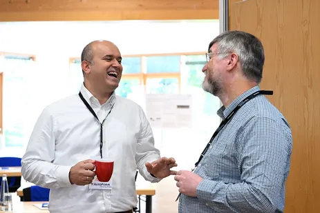 Alper Güner and Yannis Korkolis standing together in deep discussion